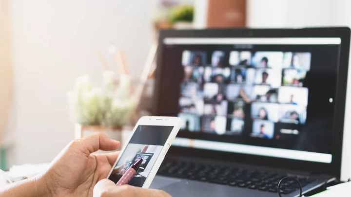 Auf einem Laptop l&auml;uft ein Online Event. Ein Teilnehmer sitzt davor