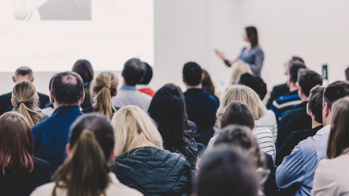 Eine Person h&auml;lt einen Vortrag auf einem Event.